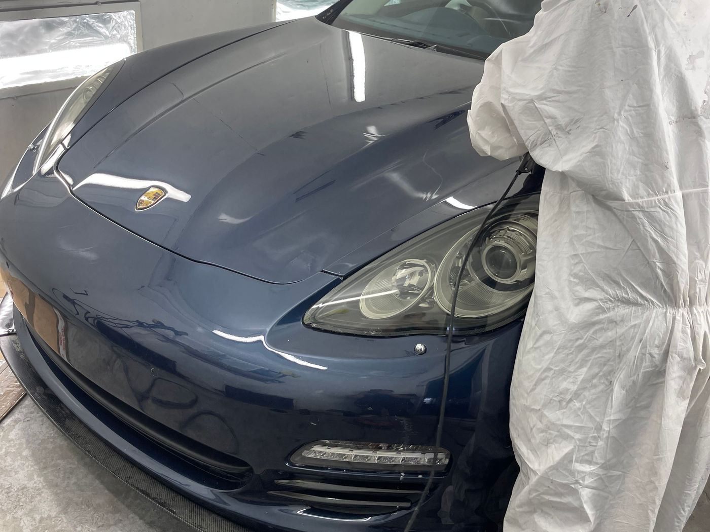 A dark blue Porsche Panamera in the N17 Bodyworks spray booth after paintwork